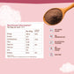 Nutritional information card with a spoonful of dark powder on a pink background